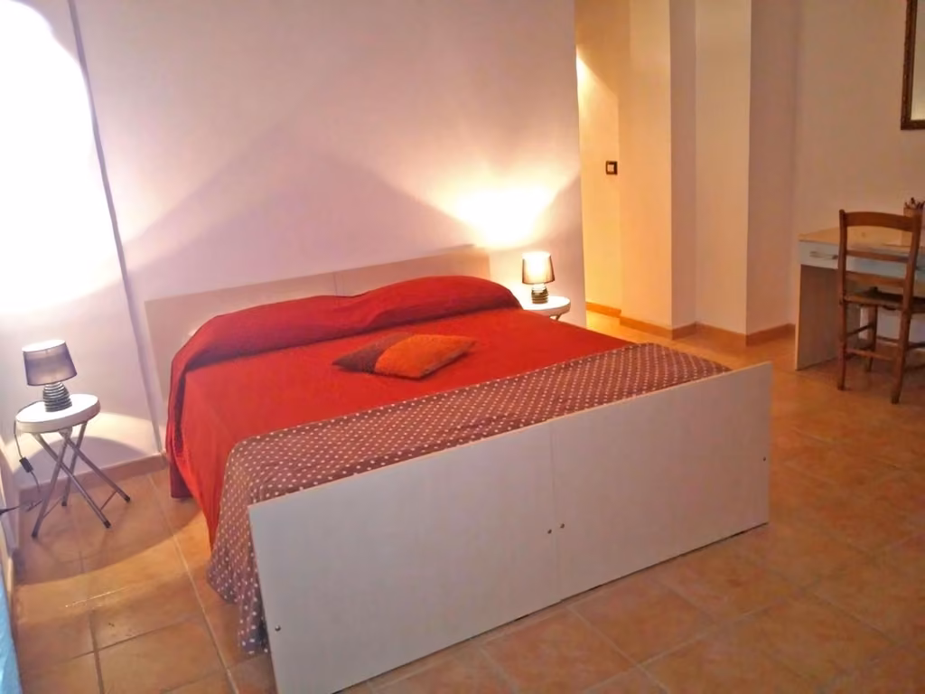 Camera matrimoniale del B&B Porta Bazzano a L'Aquila con letto con coperta rossa