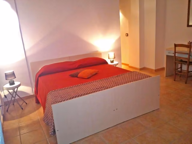 Camera matrimoniale con letto e coperta rossa
