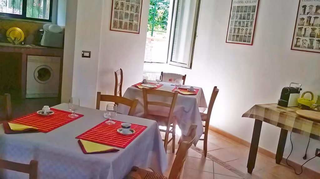 La sala da pranzo con tavoli in legno del B&B Porta Bazzano